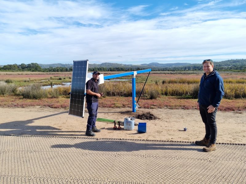 A solar powered monitoring camera being installed on a 3-meter post overlooking the Panboola Wetland